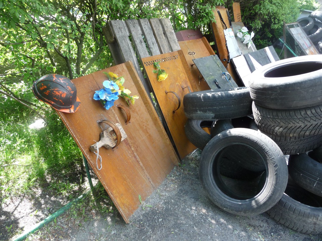 Rusted hand-held shields, now adorned with flowers